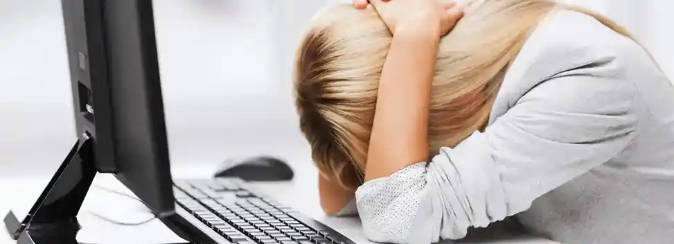 Frau vor einem Computer verzweifelt