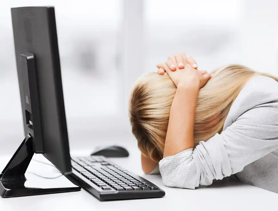 Frau vor einem Computer verzweifelt